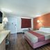 Motel 6 Newport News, VA guest room with double bed, orange accent wall, desk and window
