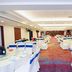 Xiamen Junming Hotel banquet hall with round tables, white chairs and blue sashes in Xiamen