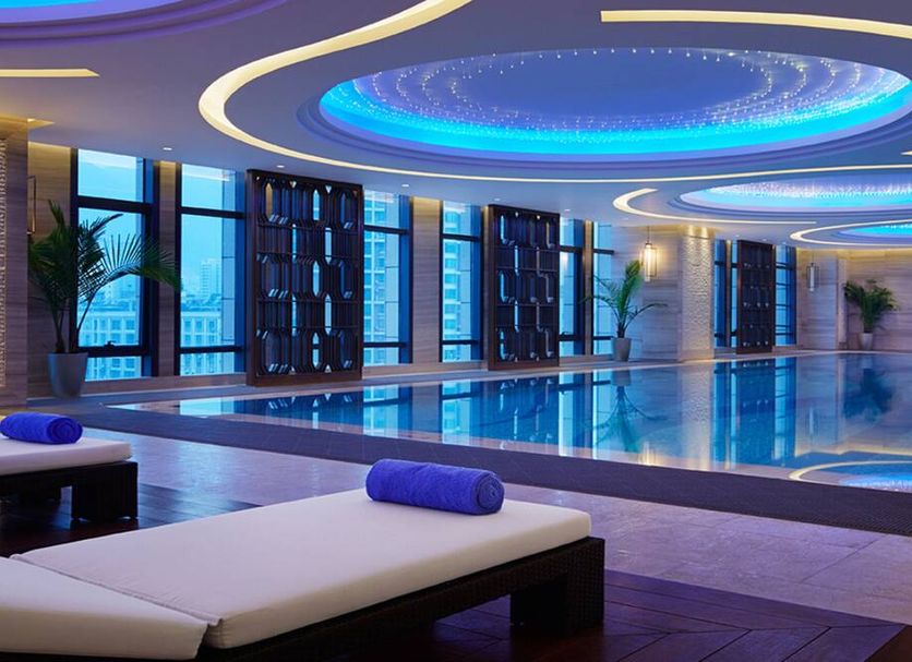 Wanda Realm Ningde indoor pool with lounge chairs and blue-lit ceiling in Ningde