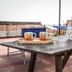 Casa Giuliana in Lipari rooftop terrace with wooden table, chairs, potted flowers and church view