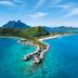 Conrad Bora Bora Nui in Vaitape with overwater villas on a turquoise lagoon and island mountain backdrop