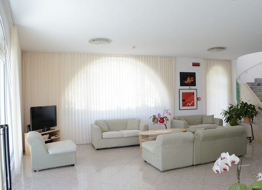 Hotel Maronti lounge in Barano d'Ischia with sofas, TV, staircase and potted plants