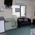 Abode On Courtenay Motor Inn room in New Plymouth with seating area, kitchenette and wall-mounted TV