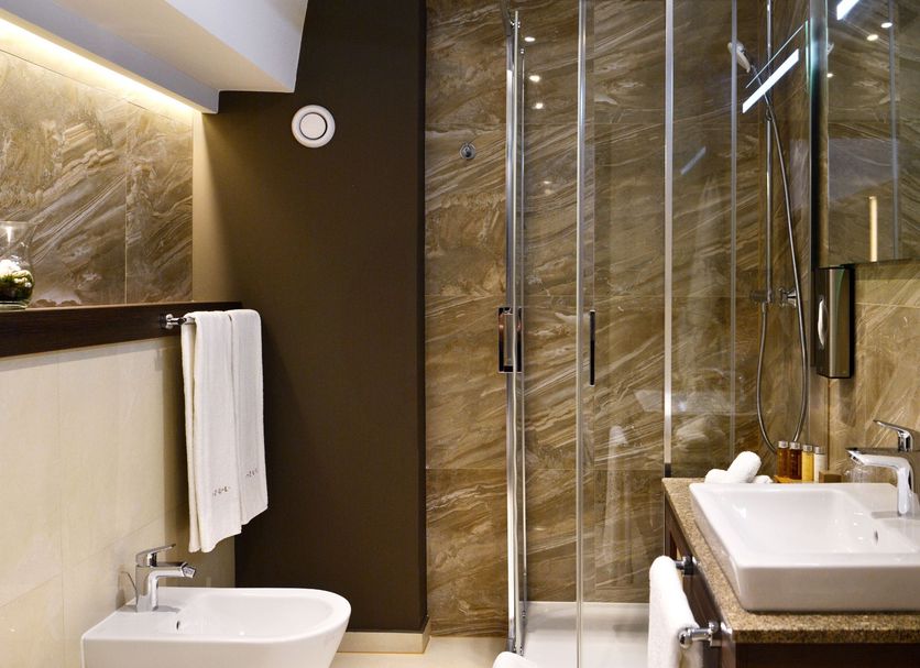 Azul Hotel & Restaurant Partizánske bathroom with glass shower, sink, vanity and towel rack