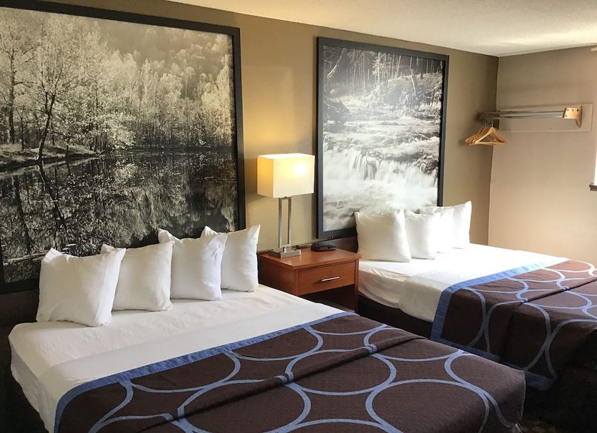 Super 8 by Wyndham Miles City guest room with two beds, bedside lamp, and framed wall art