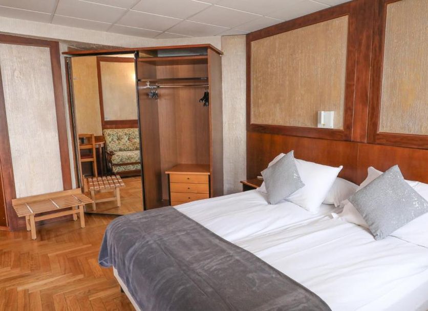 Sporting in Breuil-Cervinia guest room with double bed, open wardrobe and parquet floor