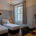 The Bedford Hotel Tavistock twin guest room with window, curtains, bedside lamps and wall-mounted TV