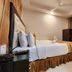 Housez 43 Kolkata guest room with king bed, wall-mounted TV, desk and ceiling fan