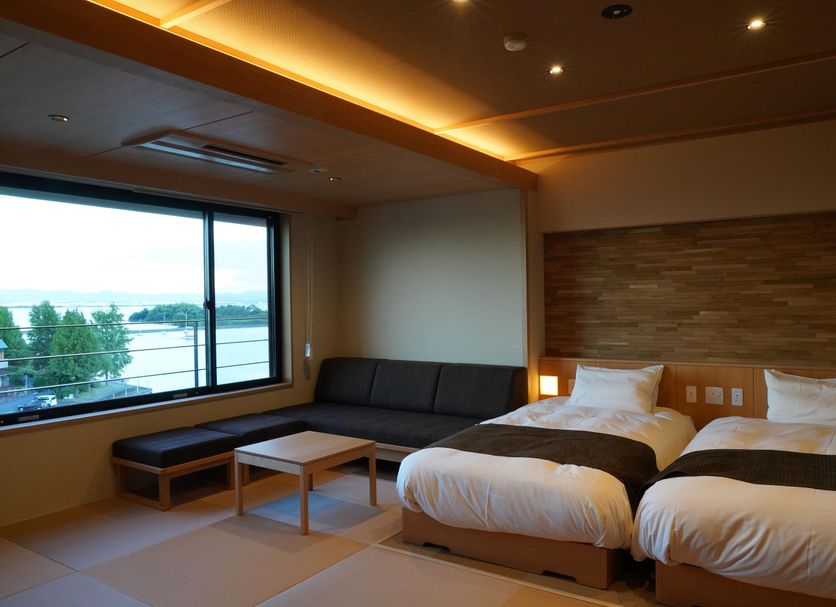 Dantokan Kikunoya in Ōtsu with twin beds, sofa, and large window overlooking the water