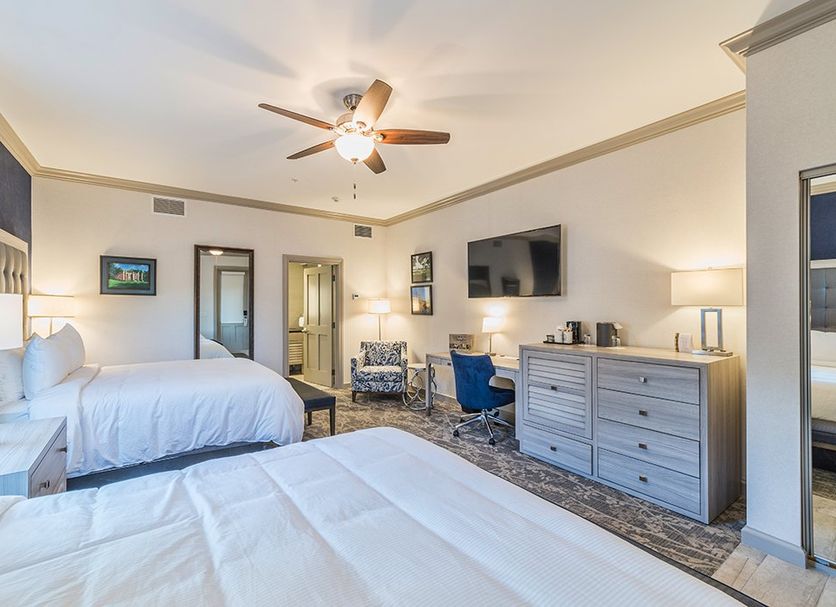The Beaufort Inn guest room in Beaufort with two beds, ceiling fan, and dresser