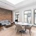 Le Merrill - Vieux Montréal in Montreal: modern suite with brick wall, dining table, sofa, and large arched windows