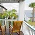 Desoto Beach Terraces, Tybee Island balcony with wooden chairs and tropical courtyard view