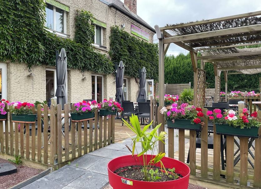 Logis Hôtel Restaurant Auberge Saint Martin in Saint-Gatien-des-Bois with ivy-covered facade and flower-filled patio