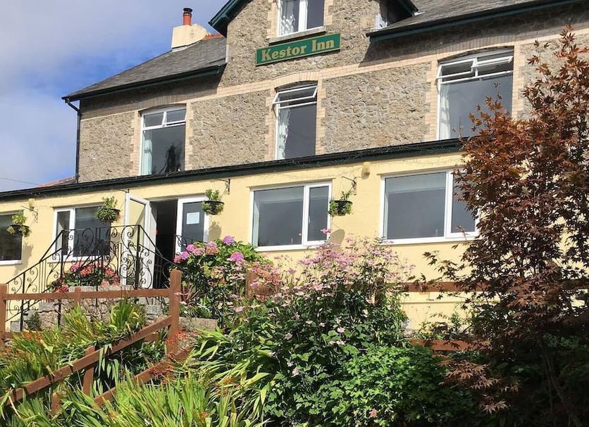 Kestor Inn in Newton Abbot with stone exterior, garden and flowering shrubs