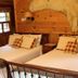 Kiwassa Lake Bed & Breakfast in Saranac Lake bedroom with two beds and rustic wood wall decor