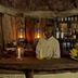 Crater Forest Tented Camp bar in Karatu with lantern lighting, wooden counter, and bartender