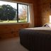 Tussock Grove Boutique in Ohakune room with bed and large window overlooking trees