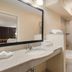 Red Roof Inn Baltimore South - Glen Burnie bathroom with vanity, mirror, toilet, and shower-tub combo