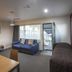 Landmark Manor Motel in New Plymouth room with sofa, bed, and open door to outdoor area