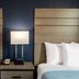 Baymont by Wyndham Laredo guest room with two beds, bedside lamp, and digital alarm clock
