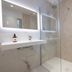 Hôtel Les Pins - Oléron bathroom with walk-in shower, vanity sink and herringbone tile wall