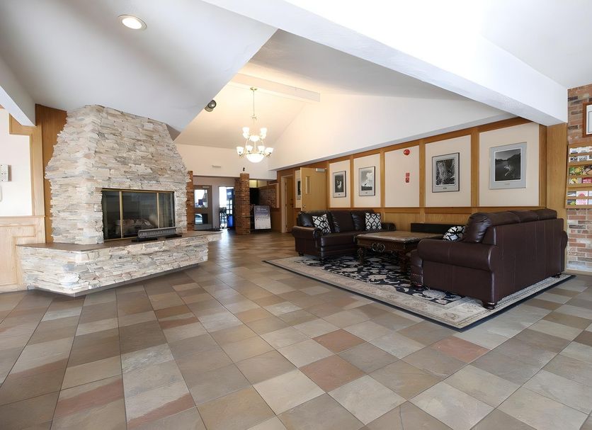 Medicine Hat Suites lobby in Medicine Hat with stone fireplace, leather seating, and tiled floors