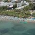 Sami Plaza in Bodrum with beach chairs, palm trees, and clear water along the shoreline