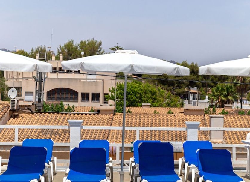 Hostal Residencia San Francisco in Portocolom with pool, blue loungers, and shaded terrace