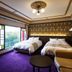 Shikino Yado Minoya Hotel in Yahiko guest room with stained-glass window, twin beds and purple carpet
