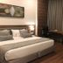 Hotel Centre Point Nagpur guest room with king bed, desk by curtains, and seating area