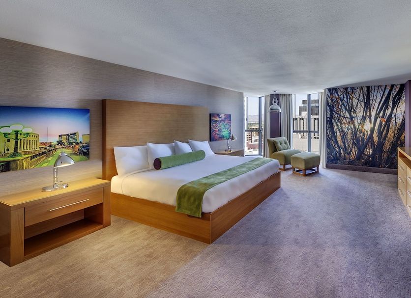 Whitney Peak Hotel Reno, Tapestry Collection by Hilton room with king bed, city view, and lounge chair