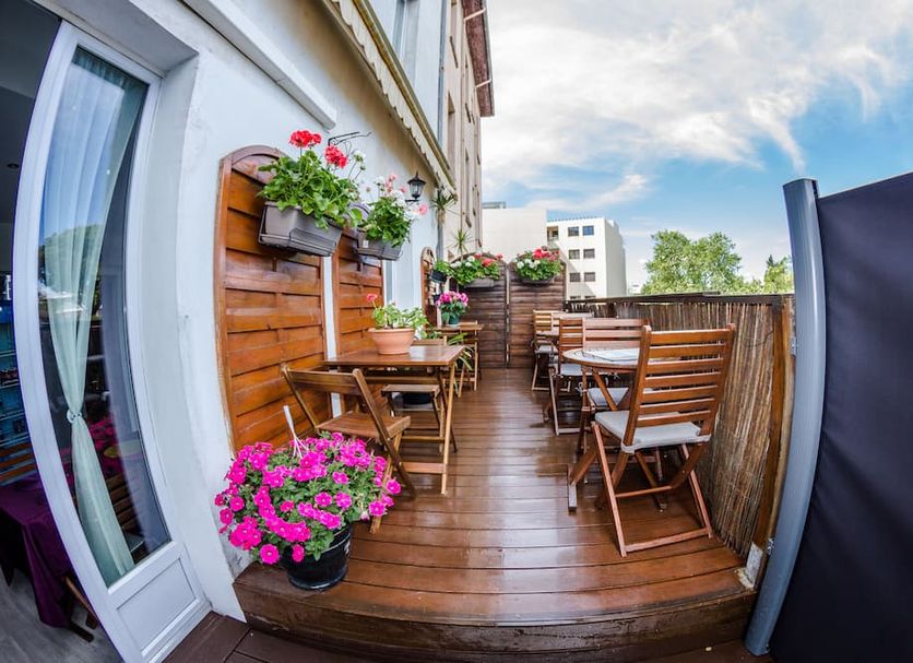 Trianon Antibes terrace with wooden tables, chairs, and flower planters