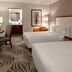 Hotel Adeline, Scottsdale guest room with two beds, desk, mirror and orange chair