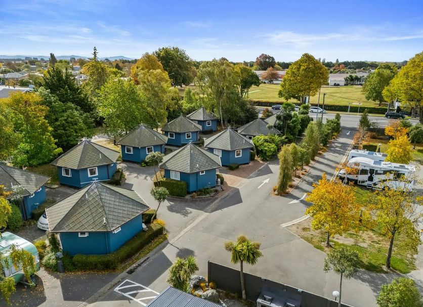Tasman Holiday Parks - Christchurch with blue cabins and tree-lined park setting in Christchurch