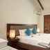 First Landing Beach Resort and Villas in Viseisei bedroom with king bed, bedside lamp and open shutters