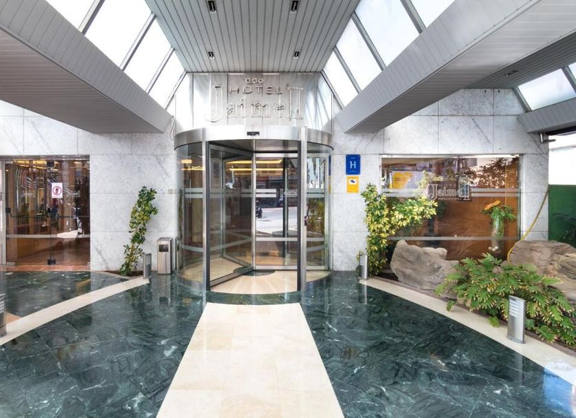 Jaime I in Benidorm lobby with glass revolving door, skylights, and decorative indoor water feature