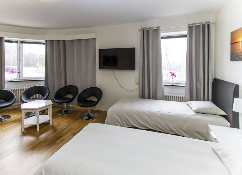 Hotell Linden in Östersund guest room with twin beds, chairs, wall TV and city-view windows