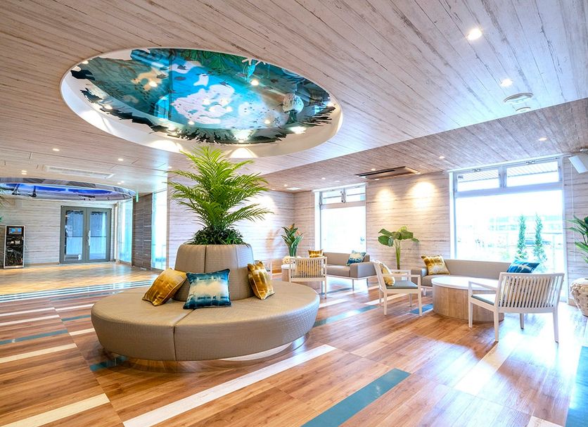 La'gent Hotel Okinawa Chatan lobby with circular sofa, tropical ceiling art and bright seating area