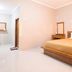 Tanjung Alam Hotel in Buleleng guest room with wooden bed, vanity, and bright minimalist interior