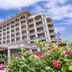 Haiqing Hotel in Qingdao exterior with grand entrance, balconies, and flowering garden