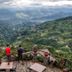 Everest Manla Resort in Nagarkot with two guests overlooking a lush mountain valley from a scenic terrace