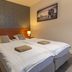 B&B Brasserie Lakerhof in Ohe en Laak bedroom with twin beds, bedside lamps, and framed wall art