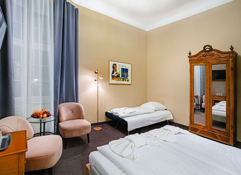 Hotel Bellevue am Kurfürstendamm room in Berlin with two beds, wardrobe, chairs and large window