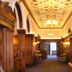 Mercure Aberdeen Ardoe House in Aberdeen, ornate wood-paneled hallway with chandeliers and arched windows