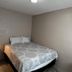 The 409 Bolivar Beach Hotel in Bolivar Peninsula guest room with a bed, bedside lamp and wall-mounted TV