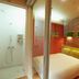 Guesthouse Nara Komachi in Nara: compact bedroom with glass-wall shower beside the bed