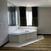 Super 8 by Wyndham Mound City room with corner jetted tub, table, lamp, and striped carpet