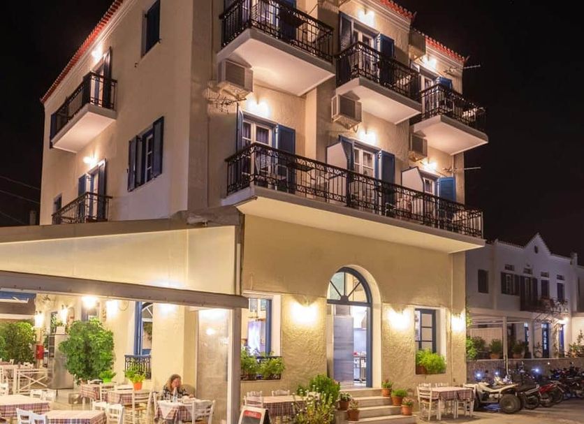 Stelios in Spétses, lit hotel exterior at night with balconies and outdoor seating