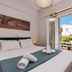 Cyclades Beach Apartments in Platis Gialos: bedroom with open balcony doors to garden and sea view