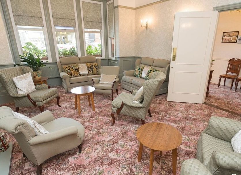 Chudleigh Hotel in Clacton-on-Sea lounge with patterned carpet, armchairs, sofa and large windows